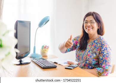 Asian senior woman smiling wearing eye glasses teaching online, Happy woman teach from home Online learning.Happy thumb up woman teacher at home.Social distancing.Online education.home school online.
