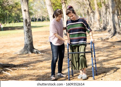 Asian Senior Woman Use Walking Aid During Rehabilitation After Knee Surgery, Young Carer Assisting Reassuring Mature Elderly People Practice Walking With Walker,female Caregiver Help,care,support 