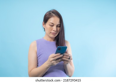 Asian Senior Woman Using Smart Phone With Blue Background.