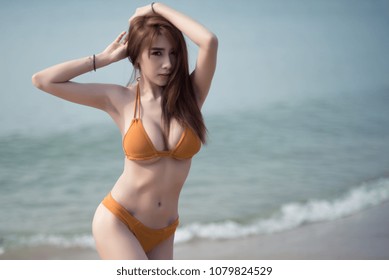 Asian Sexy Woman On The Beach In Orange Bikini