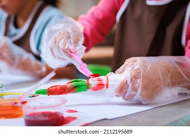 Asian Siblings Child Girl Enjoy Making Tie Dye Cloth Together At Home. Art And Craft DIY For Children Concept.