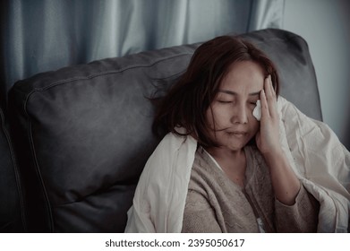 Asian sick woman sit on the sofa stay at home,The woman felt bad, wanted to lie down and rest,high fever - Powered by Shutterstock