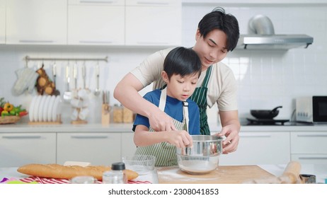 Asian single father teaching son cooking or baking spending time on holidays together in kitchen room at home. Food and cuisine concept, Happy asian family - Powered by Shutterstock