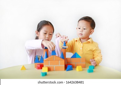 Asian Sister And Her Little Brother Playing Wood Block Toy Together. Little Boy And Girl Doing Activity Over White Background