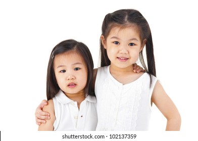 Asian Sisters Arms Around On Plain Background