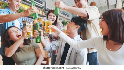 Asian Six Friends Watch Ball Games On Tv And Toasting Beer In The Restaurant