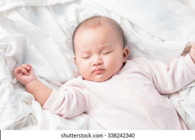 Asian Sleeping Baby On Back On White Bed