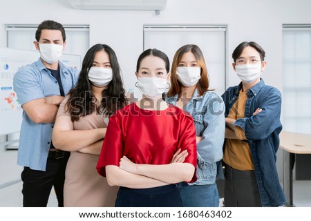 asian small business startup multiracial fighting action posture with laptop and chart paper everyone mask for covid19 protection corona flu prevent healty ideas concept office background