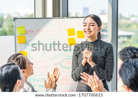 Asian smart woman present work and got praise and complement from team colleague. People applaud hands with happy smile congratulation in meeting room. Business finance, communication planning concept