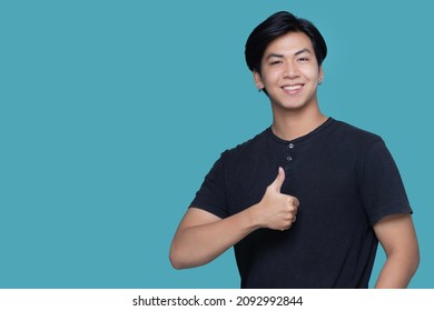 Asian Smart Young Man Thumb Up Isolated On Blue Color Background With Copy Space.