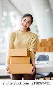 Asian SME Business Women Use Laptop Computer Checking Customer Order Online Shipping Boxes At Home. Starting Small Business Entrepreneur SME Freelance. Online Business, Work At Home Concept.