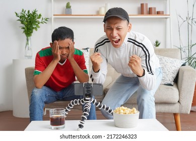 An Asian soccer fans emotionally watching game in the living room. - Shutterstock ID 2172246323