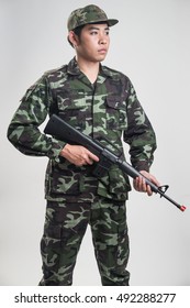 Asian Soldier In Green Camouflage Uniform With Long Gun