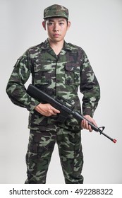 Asian Soldier In Green Camouflage Uniform With Long Gun