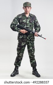 Asian Soldier In Green Camouflage Uniform With Long Gun