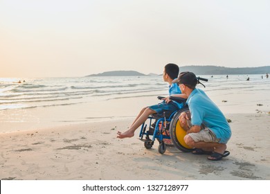 Asian special child on wheelchair and his dad on the beach at sunset, Father helped him to get closer to nature, Life in the education age of disabled children, Happy disabled kid concept. - Shutterstock ID 1327128977