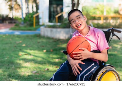 Asian special child on wheelchair is playing basket ball to strengthen muscles in the outdoor park, Lifestyle of disability child, Life in the education age, Happy disabled kid in homeschool concept.