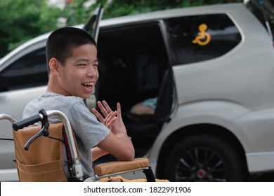 Asian Special Child On Wheelchair By The Car Door Going Up On A Car Parked In A Disabled Parking Space, Using A Disabled  Children Vehicle, Happy Special Need Kids Concept.