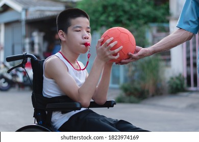 Asian Special Child On Wheelchair Playing Chair Ball/ Basketball To Strengthen Muscles,Lifestyle Of Disabled Child,Life In The Education Age Of Children,Happy Disability Kid With Home School Concept.