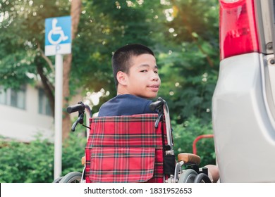 Asian Special Child On Wheelchair Going Up On A Car Parked In A Disabled Parking Space, Using A Disabled Children Vehicle,Lifestyle In Education Age Of Disability Boy, Happy Special Need Kids Concept.