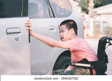 Asian Special Child On Wheelchair By The Car Door Going Up On A Car Parked In A Disabled Parking Space, Using A Disabled  Children Vehicle, Happy Special Need Kids Concept.