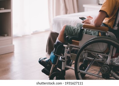 Asian special child on wheelchair is have intention with using smart phone alone in bedroom background,Real people's pictures of daily life in the home,Life in the education age of disabled children.