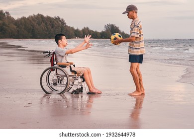 Asian Special Child On Wheelchair Is Fun, Playing Ball And Exercise Activity On Sea Beach At Summer, Lifestyle Of Disability Child, Life In The Education Age, Happy Disabled Kid In Travel Concept