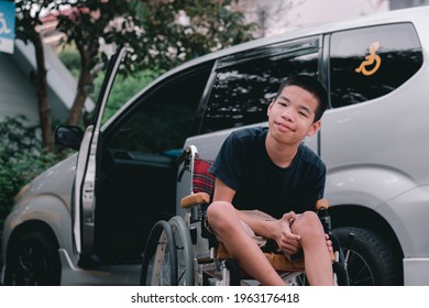 Asian Special Child On Wheelchair By The Car Door Going Up On A Car Parked In A Disabled Parking Space, Using A Disabled  Children Vehicle, Happy Special Need Kids Concept.