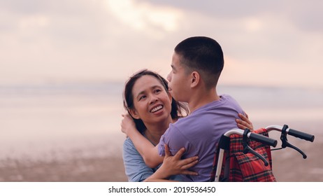 Asian Special Child On Wheelchair On The Beach With Parents In Family Holiday To Travel, Exercise And Learning About Nature Around The Sea Beach, Life In The Education Age, Happy Disabled Kid Concept.