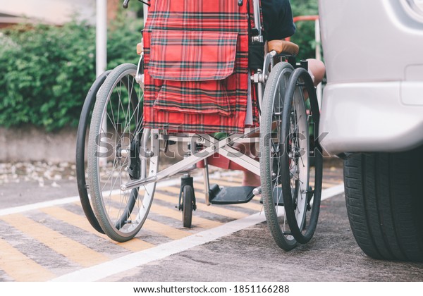 Asian special child on wheelchair beside the car\
on the parking space for disabled people, Life in the education age\
and public transport of disabled children, Disability kids\
transportation concept.