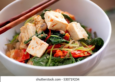 Asian Spicy Stir Fry Vegetable With Tofu And Beans In White Bowl And Chopsticks Closeup