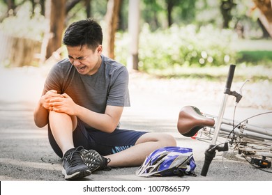 Asian Sport Young Man Cyclist Riding Mountain Bike Accident Spin Down And Fall Knee Injured On Road. Sport Life Healthy Concept In The Summer