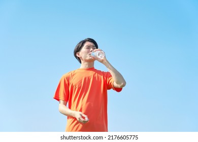 Asian Sportsman Drinking Under The Clear Sky