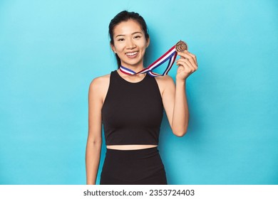 Asian sportswoman with gold medal, celebrating victory. - Powered by Shutterstock