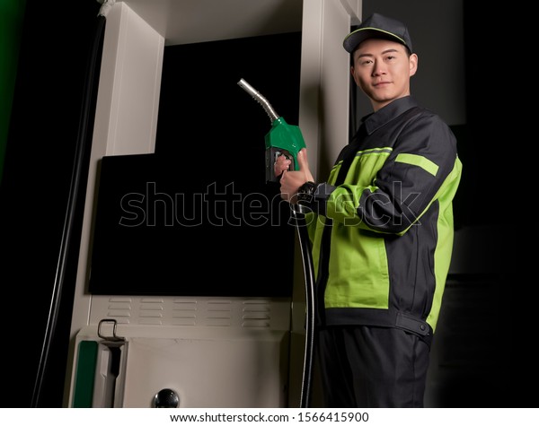 Asian staff holding a\
gas gun at night