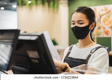 Asian Staff Restaurant Waitress Wear Protective Face Mask Working In The Restaurant With Social Distancing To Protect Infection From Coronavirus Covid-19