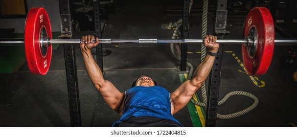 Asian Strong Athletic Man Having Workout And Bodybuilding With Barbells Weight Lift In Gym And Fitness Club In Dark Tone