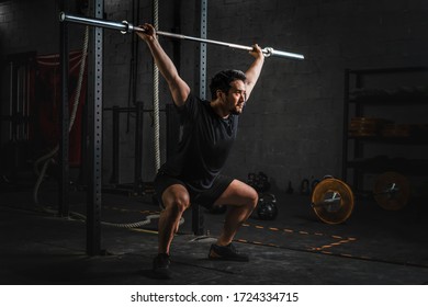 Asian Strong Athletic Man Having Workout And Bodybuilding With Barbells Weight Lift Over Head Squat Style In Gym And Fitness Club In Dark Tone