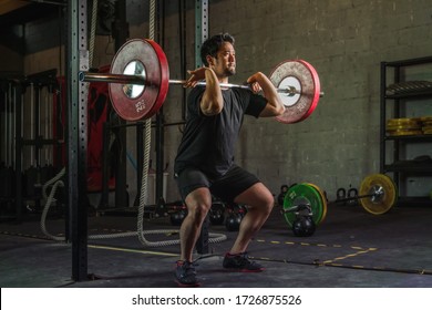 asian strong athletic man having workout and bodybuilding with barbells weight front squat setting style in gym and fitness club in dark tone - Powered by Shutterstock