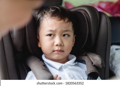 Asian Stubborn Child Baby Boy While Mother Scolding On Car Seat In The Car When He Go Back To School In The Morning.Little Asian Toddler Boy In Booster Seat Make Boring Face.Transportation Safe Trip.