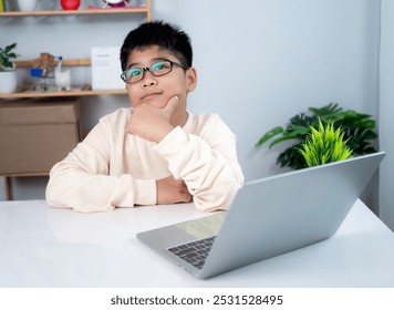 Asian student boy thinking using computer learning. Educational of tech concept, Staying at home, Presenting a modern educational way of life. Virtual internet online class from school teacher. - Powered by Shutterstock