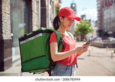 Asian Student Delivering Food Through City Using Mobile Phone