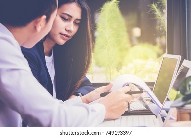 Asian Student Getting Help From Tutor In Cafeteria At The University