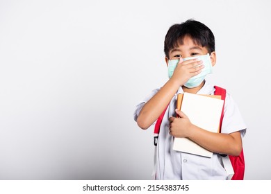 Asian Student Kid Boy Wearing Student Thai Uniform And Medical Protect Face Mask And Hand Cover Mouth In Studio Shot Isolated On White Background, New Normal Back To School