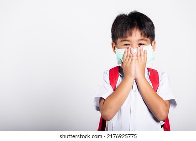 Asian Student Kid Boy Wearing Student Thai Uniform And Medical Protect Face Mask And Hand Cover Mouth In Studio Shot Isolated On White Background, New Normal Back To School