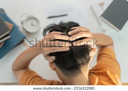 Asian student man have anxiety because of exams, male prepare for test and learning lessons in the library. stress, despair, haste, misunderstanding reading, discouraged, expectation, knowledge, tired