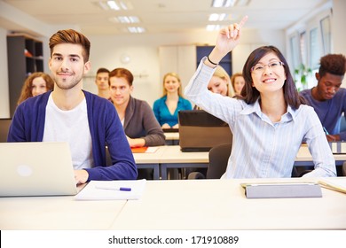 Asian Student Raising Her Hand In A University Classroom