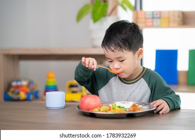 Asian student take a lunch in class room by food tray prepared by his preschool, this image can use for food, school, kid and education concept - Powered by Shutterstock