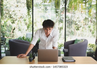 asian student using computer for learning leasson online at cafe. startup man working with laptop at office.  young male entrepreneur analyze financial data at workplace. business, education concept