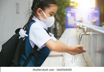 Asian Student  Washing Hands At The Outdoor Wash Basin In The School. Preventing Contagious Diseases, Plague. Kids Health, Protecting The Virus Covid - 19 , Saving Water, Cleaning, Running Water.